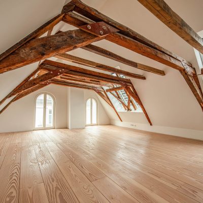 Fertiggestellter Dachraum mit sichtbarem historischem Holztragwerk