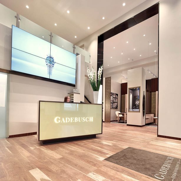 Empfangsbereich von Juwelier Gadebusch mit beleuchteter Theke und großem Bildschirm