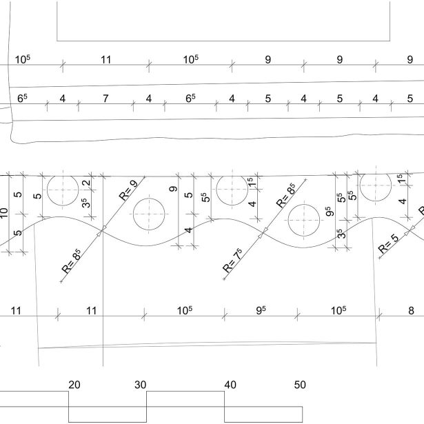 Restaurierte Holzbalken mit roten Zierelementen an der Fassade
