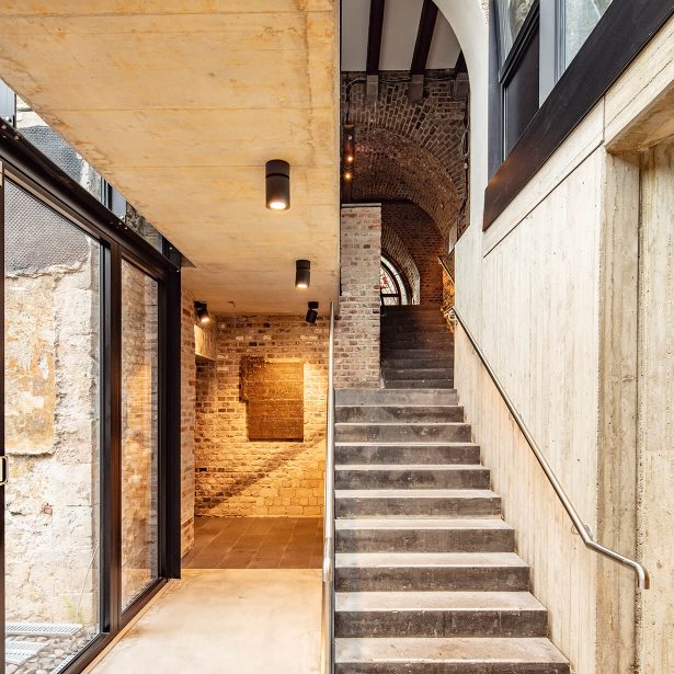 Treppenanlage mit Sichtbeton, Backsteinmauerwerk und moderner Verglasung